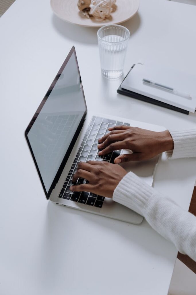 Person in White Long Sleeve Shirt Using Macbook Pro